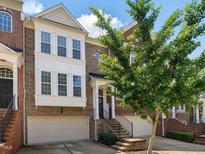 Charming brick townhome featuring an attached garage and welcoming front entrance at 8722 Macedonia Lake Dr, Cary, NC 27518