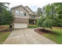 Charming two-story home with a well-maintained yard, a two-car garage, and a welcoming front porch at 1009 Blue Larkspur Ave, Wake Forest, NC 27587
