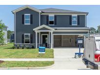 Two-story home featuring a two-car garage, well-maintained lawn and traditional architectural details at 1105 Landen Creek Ln, Zebulon, NC 27597