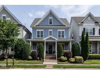 Charming blue two-story home featuring a landscaped yard and inviting front porch at 1206 Chalk Maple Dr, Cary, NC 27519