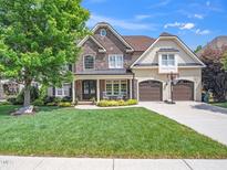 Stunning two-story home with a stone and siding exterior, well-manicured lawn, and a two-car garage at 12424 Beauvoir St, Raleigh, NC 27614
