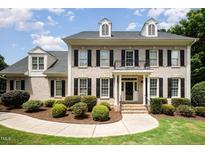 Elegant brick home with a manicured lawn, black shutters, and a charming entrance at 1401 Brewer Jackson Ct, Wake Forest, NC 27587