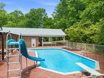 Backyard pool area featuring a slide, diving board, covered patio area, and plenty of space for outdoor enjoyment at 1514 Lawrence Rd, Creedmoor, NC 27522