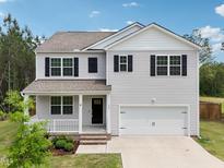 Charming two-story home with gray siding, black shutters, a covered porch, and a two-car garage at 170 Baker Farm Dr, Youngsville, NC 27596