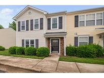 Two-story townhome featuring black shutters, neutral siding, and landscaping at 2018 Grassy Banks Dr, Raleigh, NC 27610