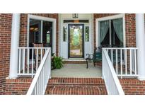 Inviting front entrance features brick steps, white railings, and a beautifully detailed glass door at 204 Muirfield Ln, Clayton, NC 27527