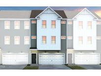 Charming townhome facade with a clean modern design and attached garage, showcasing a welcoming curb appeal at 2135 Grouse Ski Cir, Apex, NC 27523
