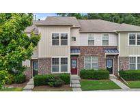 Attractive townhouse with brick accents, landscaped front yard, and colorful doors at 220 Mount Evans Dr, Durham, NC 27705