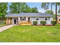 Charming one-story home with gray siding, a freshly painted white brick facade, and a new wood deck at 2200 Wyman Pl, Durham, NC 27707