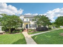 Charming two-story home featuring a well-manicured lawn, mature trees, and inviting walkway at 231 Heather Bluffs Dr, Garner, NC 27529