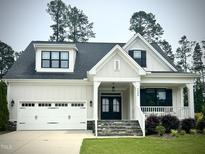 Charming two-story home featuring a two-car garage, stone steps, and a welcoming front porch at 2500 Plowridge Rd, Fuquay Varina, NC 27526