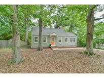 Charming single-story home featuring a delightful orange front door surrounded by lush greenery and mature trees at 2602 Francis St, Durham, NC 27707