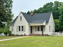 Charming home featuring fresh exterior paint, a cozy front porch, and an inviting landscaped yard at 2714 Wedgedale Ave, Durham, NC 27703