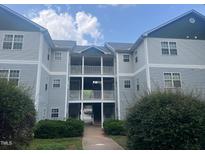 Attractive three-story condo building with balconies and professional landscaping at 3000 Centennial Woods Dr # 302, Raleigh, NC 27603