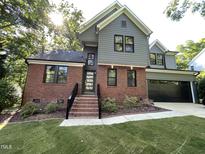 Beautiful two-story home with a brick and gray siding exterior, manicured lawn, and attached two-car garage at 306 Roebling Ln, Cary, NC 27513
