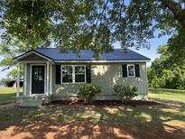 Charming single-story home with a newly installed black metal roof and neatly landscaped front yard at 317 Brewer Rd, Louisburg, NC 27549
