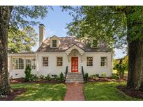 Charming two-story home featuring a red front door, brick walkway, and well-manicured lawn at 3210 Merriman Ave, Raleigh, NC 27607
