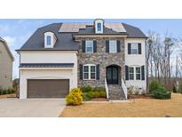 Beautiful two-story home with stone and painted brick, professional landscaping, and solar panels at 329 Royal Delta Dr, Cary, NC 27519