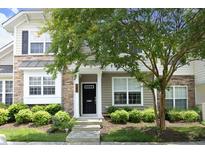 Charming two-story home with stone accents, a black front door, and lush landscaping at 365 Red Elm Dr, Durham, NC 27713