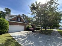 Charming two-story brick home featuring an attached garage and a well-maintained landscaped front yard at 3713 Coach Lantern Ave Ave, Wake Forest, NC 27587