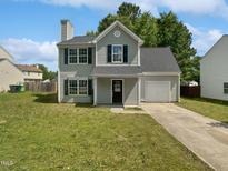Charming two-story home with an attached garage and a well-maintained lawn on a sunny day at 4509 Cobble Creek Ln, Raleigh, NC 27616