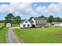 Beautiful two-story white farmhouse with black shutters, a charming front porch, and a lush green lawn at 4600 Smithfield Rd, Wendell, NC 27591