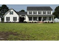 Charming two-story home with black shutters, white siding, a covered porch, and green lawn at 4600 Smithfield Rd, Wendell, NC 27591