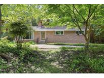 Charming brick home with a well-manicured front yard and mature trees at 712 Beaver Dam Rd, Raleigh, NC 27607