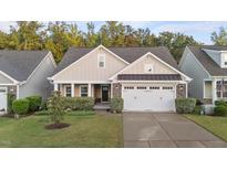 Charming home featuring a two-car garage, well-manicured lawn, and classic architectural details at 80 Bramble Ln, Clayton, NC 27527