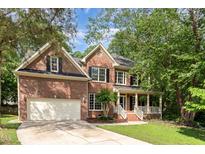 Traditional two-story brick home with an attached two-car garage and mature landscaping at 8816 Valley Springs Pl, Raleigh, NC 27615