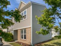 Charming townhouse with brick accents and neutral siding, surrounded by lush greenery at 8891 Commons Townes Dr, Raleigh, NC 27616