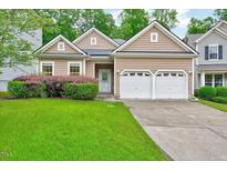 Charming home featuring a well-manicured lawn, tidy shrubbery and a two car garage at 921 Shefford Town Dr, Rolesville, NC 27571