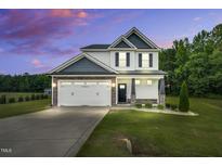 Charming two-story home with a two-car garage and beautifully landscaped front yard at 97 Arapahoe Dr, Kenly, NC 27542
