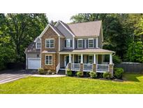 Charming two-story home with stone accents, a welcoming front porch, and lush green lawn at 973 Rebecca Ln, Siler City, NC 27344