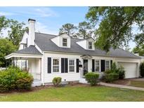 Charming home with a manicured lawn, classic white facade, black shutters, and a welcoming front porch at 1001 N Orange Ave, Dunn, NC 28334