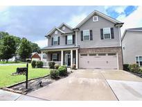 Inviting two-story home featuring gray siding, black shutters, and a well-manicured lawn at 101 Claystone Dr, Gibsonville, NC 27249