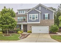 Beautiful two-story home with brick and siding, an attached two car garage, and a meticulously manicured front lawn at 112 Filigree Way, Durham, NC 27713