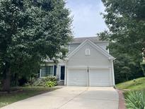 Charming two-story home featuring a two-car garage and well-maintained front yard, framed by mature trees at 122 Button Rd, Morrisville, NC 27560