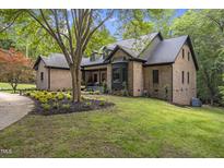 Charming brick home with a well-manicured lawn and mature trees, offering a serene and inviting curb appeal at 13121 Melvin Arnold Rd, Raleigh, NC 27613