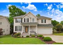 Charming two-story home with a manicured front yard, covered porch, and attached two-car garage at 1480 Big Leaf Loop, Apex, NC 27502