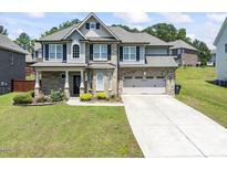 Charming two-story home featuring brick and siding, complemented by a well-manicured lawn and inviting curb appeal at 1499 Fireside Ln, Creedmoor, NC 27522