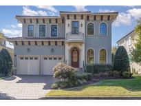 Stunning two-story home features a stucco exterior, arched windows and a charming front balcony at 15 Treviso Pl, Durham, NC 27707