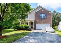 Charming two-story home featuring a brick facade, a covered front porch, and a well-maintained lawn at 18 Gwendolyn Cir, Durham, NC 27703