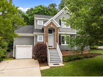 Charming two-story home featuring a brick entrance, landscaped yard, and a convenient one-car garage at 205 Town Creek Dr, Cary, NC 27519