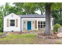 Charming white cottage with blue door, stone accents, wood shutters, and welcoming front porch at 212 E Rockway St, Durham, NC 27704