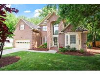 Charming two-story brick home featuring a well-manicured lawn and an attached two car garage at 216 Lewey Brook Dr, Cary, NC 27519