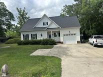Charming two-story home featuring a well-maintained lawn and attached two car garage at 2436 Nc 97, Zebulon, NC 27597