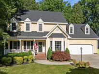 Inviting two-story home with manicured landscaping, dormers, and a charming front porch at 2645 Ridgewell Ct, Raleigh, NC 27613