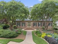 Traditional brick home with manicured landscaping, mature trees, and inviting brick pathway at 4109 City Of Oaks Wynd, Raleigh, NC 27612