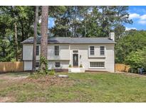 Charming white brick home featuring a well-maintained lawn and mature trees in a serene setting at 4504 Ryegate Dr, Raleigh, NC 27604